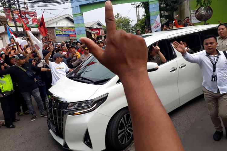 Kendaraan Prabowo Subianto saat melintas di kerumunan massa pendukung Jokowi di Jalan KH Tambak Deres Surabaya, Selasa (19/2/2019)