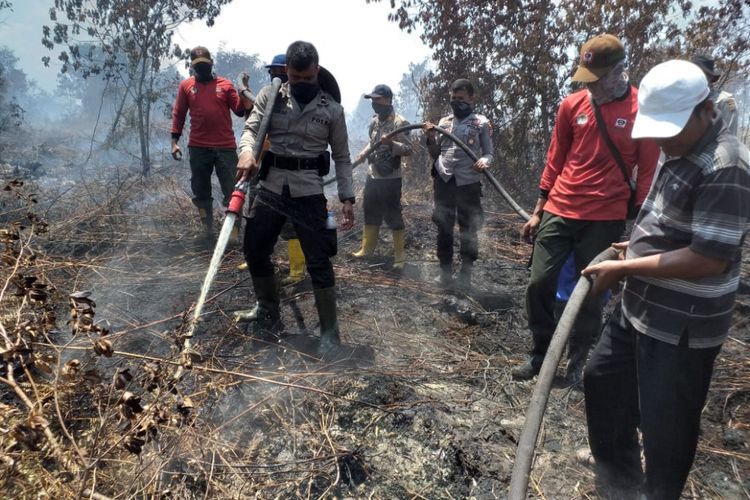 Petugas gabungan dari kepolisian, Manggala Agni, Damkar dan masyarakat berjibaku mematikan api kebakaran lahan di Kelurahan Pergam, Kecamatan Rupat, Bengkalis, Riau, Rabu (20/2/2019).