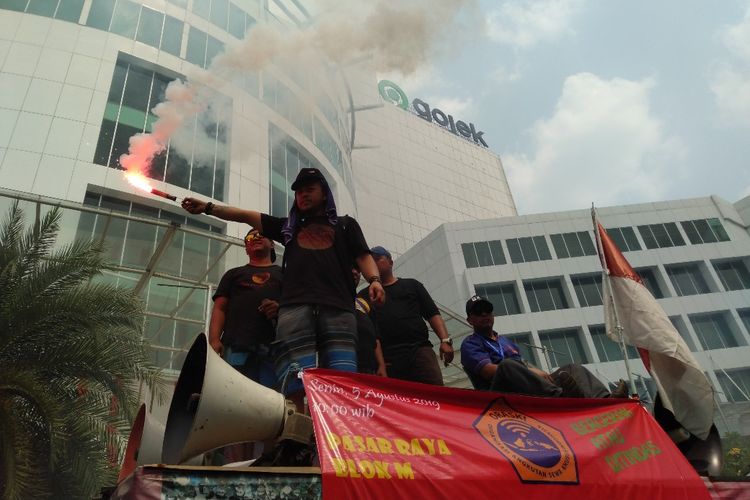 Massa aksi menghidupkan flare di depan kantor Gojek di Jalan Iskandarsyah, Melawai, Blok M, Jakarta Selatan, Senin (5/8/2019).