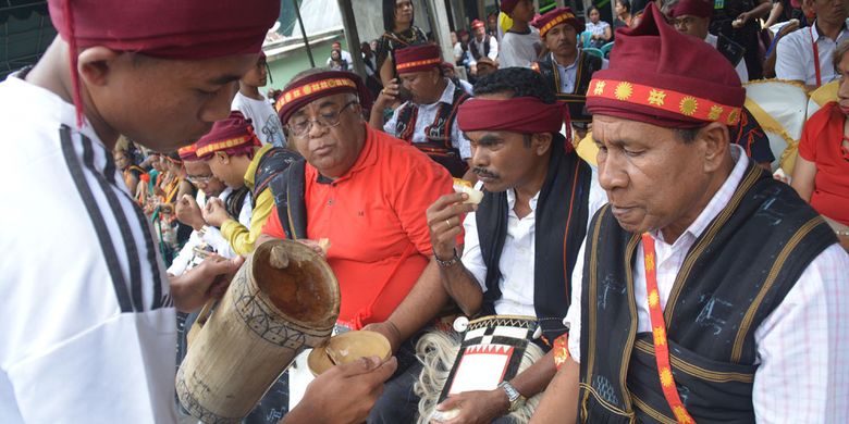 Kaum laki-laki Ngada ditugaskan untuk menyuguhkan tuak atau moke lokal untuk menggantikan minuman air setelah makan uwi (ubi) saat ritual Reba Ngada dilaksanakan di Kampung Langa, Kecamatan Bajawa, Kabupaten Ngada, Flores, NTT, Selasa (15/1/2019). 