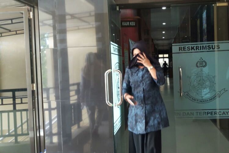 Isyanti Syam, istri mantan bupati Konawe Utara menutup wajahnya usai diperiksa KPK di Polda Sultra. 