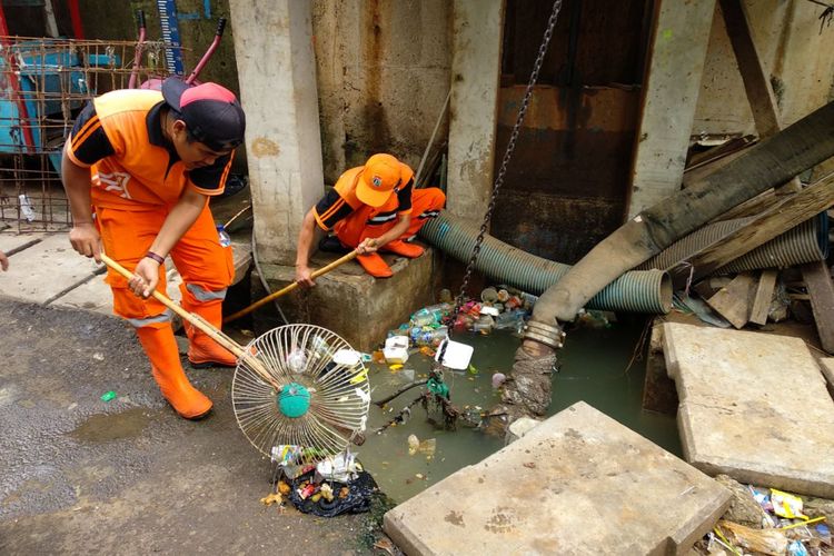 Petugas PPSU Kelurahan Kampung Melayu bekerja membersihkan sampah yang menyumbat saluran air di wilayah Kampung Pulo, Jakarta Timur, Rabu (13/12/2017). Ini dilakukan untuk persiapan menghadapi musim penghujan yang berlangsung belakangan ini.