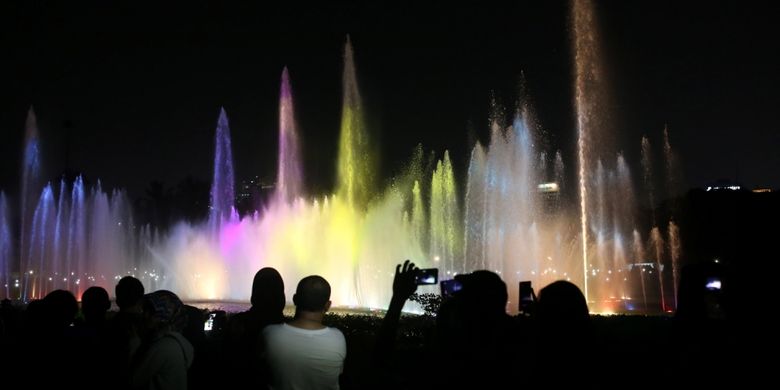 Warga menonton air mancur menari atau Jakarta Monas Fountain di Monas, Jakarta Pusat, Minggu (13/8/2017). Air mancur menari kembali diresmikan oleh Gubernur DKI Jakarta Djarot Saiful Hidayat setelah rampung diperbaiki sejak rusak pada 2009.
