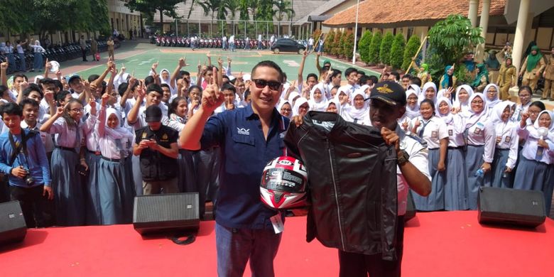 Head of Marketing PT Wahana Makmur Sejati Ario, saat memberikan hadiah berupa helm, jaket, dan sarung tangan kepada Slamet Gunaedi, di SMAN 4 Tangerang Selatan, Senin (4/2/2019)