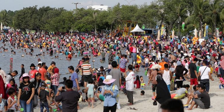 Pengunjung memanfaatkan liburan mengunjungi pantai di kawasan Taman Impian Jaya Ancol, Jakarta, Selasa (27/6/2017). Sejumlah lokasi wisata di Jakarta padat pengunjung pada libur lebaran. 