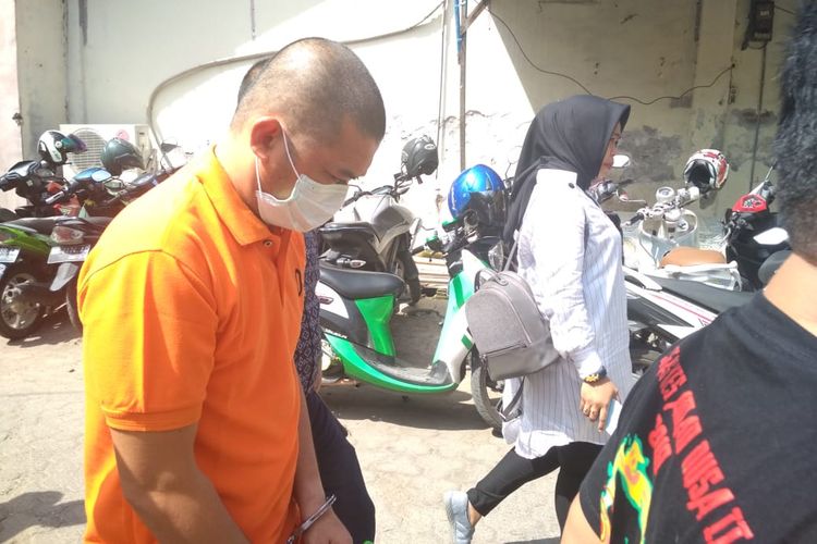 WJ (pakai masker) tertunduk saat dibawa ke klinik kejiwaan Rumah Sakit Bhayangkara Makassar oleh penyidik Polres Gowa, Selasa (26/3/2019).