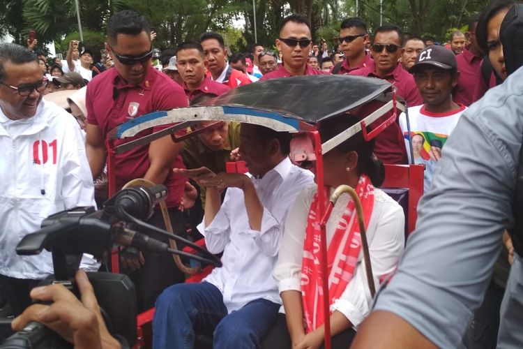 Jokowi bersana Iriana Jokowi saat menuju lokaai kampanye akbar di Lapangan Karebosi Makassar, Sulawesi Selatan, Minggu (31/3/2019).