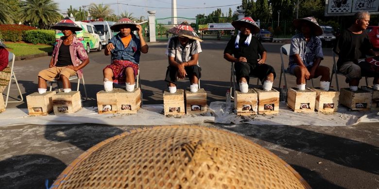 Petani dari kawasan Pegunungan Kendeng, Kabupaten Rembang, Jawa Tengah, kembali melakukan aksi protes dengan menggelar aksi mencor kaki dengan semen di depan Istana Negara, Jakarta, Senin (13/3/2017). Aksi tersebut mereka lakukan sebagai bentuk protes terhadap izin lingkungan baru bagi PT Semen Indonesia yang diteken Gubernur Jawa Tengah Ganjar Pranowo.