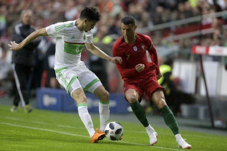 Cristiano Ronaldo mencoba melewati kawalan Zidane Ferhat pada laga uji coba Portugal vs Aljazair di Lisbon, 7 Juni 2018. 