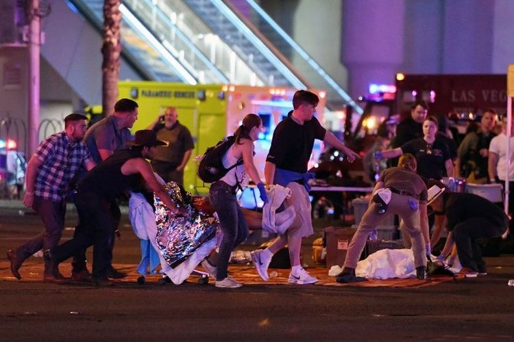 Korban dibawa ke tempat aman setelah terjadi penembakan massal di festival musik country di Las Vegas, Nevada, Minggu (1/10/2017). Seorang pria bersenjata melepaskan serentetan tembakan di festival musik di Las Vegas hingga menewaskan lebih dari 20 orang. Polisi telah menembak mati seorang tersangka.