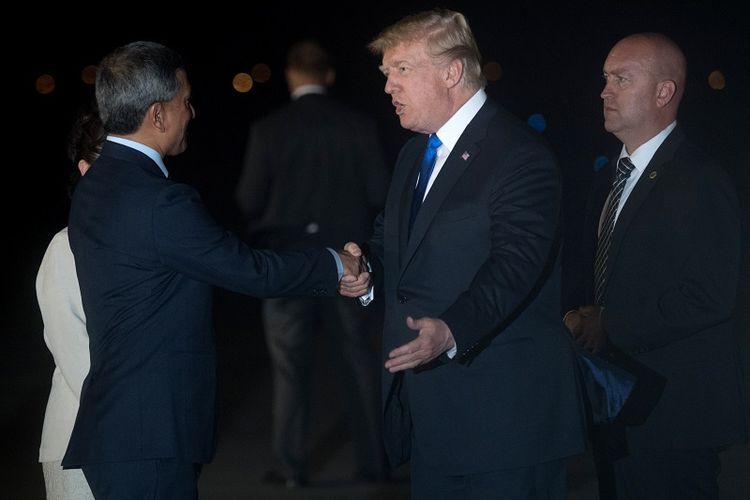 Presiden AS Donald Trump disambut Menlu Singapura Vivian Balakrishnan sesaat setelah turun dari pesawat Air Force One di Pangkalan AU Paya Lebar, Minggu (10/6/2018) malam. 