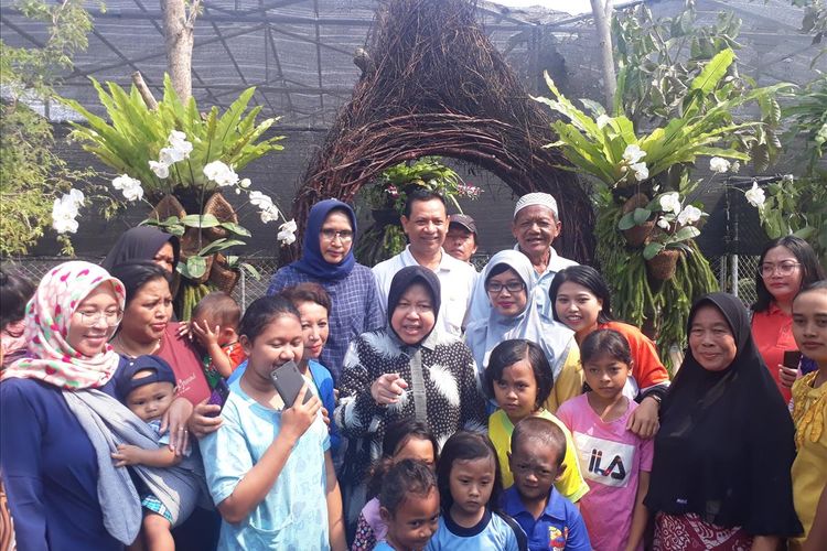 Wali Kota Surabaya Tri Rismaharini foto bersama warga di kebun bunga anggrek yang berada dikawasan eks lokalisasi Sememi, Jalan Sememi Jaya II, Kecamatan Tandes, Surabaya, Sabtu (27/7/2019).