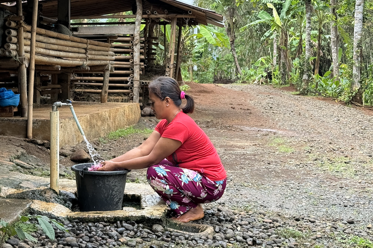 Salah satu warga Desa Srowot, Kalibagor, Kabupaten Banyumas, Jawa Tengah, sedang menikmati aliran air bersih langsung dari keran di depan rumahnya, setelah ada sumur bantuan dari Kementerian Pertahanan dan Universitas Pertahanan. Gambar diambil pada Sabtu (2/12/2023).