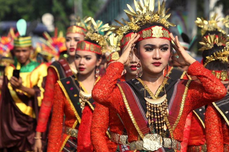 Ratusan peserta karnaval dengan menggunakan pakaian adat trasional daerah, mengikuti karnaval budaya nusantara di kawasan Rawamangun, Jakarta Timur, Minggu (28/10/2018). Karnaval mengambil tema Bangun Pemuda, Satukan Indonesia diadakan dalam rangka memperingati Hari Sumpah Pemuda ke-90.