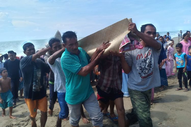 Warga mengevakuasi jenazah Musli,  nelayan yang tewas tersambar petir di pinggir pantai Desa LHOKS Puuk, Kecamatan Seunuddon, Aceh Utara, Aceh,  Selasa (21/5/2019)