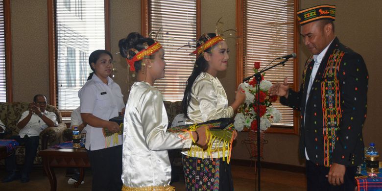 Staf Pemerintah Daerah Kabupaten Manggarai, Flores, NTT mengenakan jas kain tenun songke kepada Gubernur NTT, Viktor Bungtilu Laiskodat saat kunjungan kerjanya di Kabupaten Manggarai Timur di ruang kerja Bupati Manggarai, Rabu (9/1/2019). 