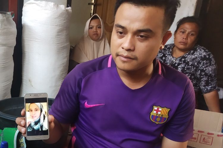 Kasim sedang menunjukkan foto kakaknya, Kaini, salah satu korban TKW yang meninggal akibat kebakaran di Arab Saudi, Minggu (23/6/2019). 