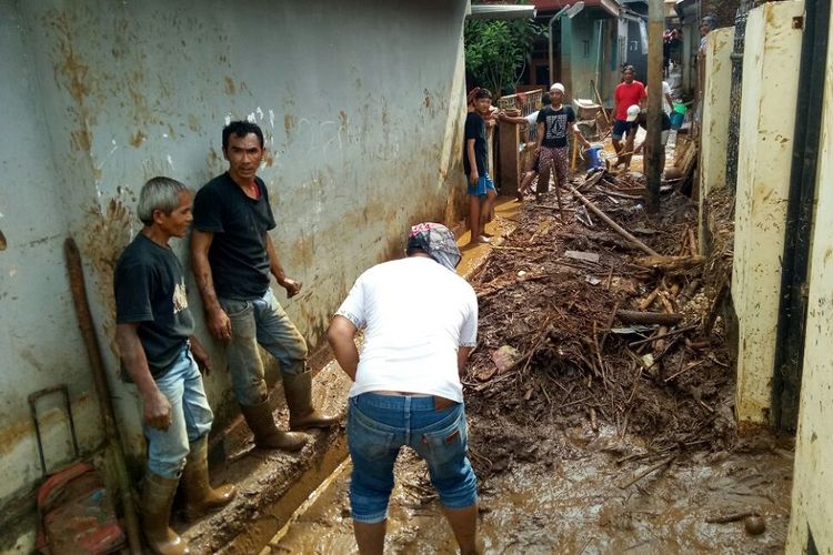 Pasca banjir bandang, warga RT 2 RW 4 Kelurahan Jatihandap, Kecamatan Mandalajati, Kota Bandung, tengah bergotong royong membersihkan lumpur dan tumpukan dahan pohon yang tertimbun di gang permukiman warga, Rabu (21/3/2018).
