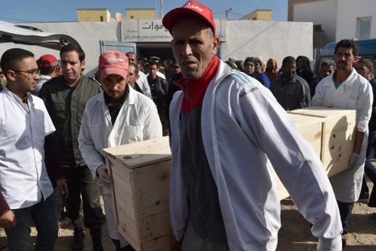 Petugas mengangkat peti berisi jenazah korban kerumunan massa di kota Sidi Boulaalam.