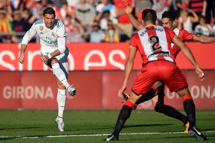 Penyerang Real Madrid, Cristiano Ronaldo (kiri), melepaskan tembakan yang berusaha dihalau pemain Girona, Juan Pedro Ramirez, dalam pertandingan La Liga di Stadion Municipal de Montilivi, Girona, Minggu (29/10/2017).