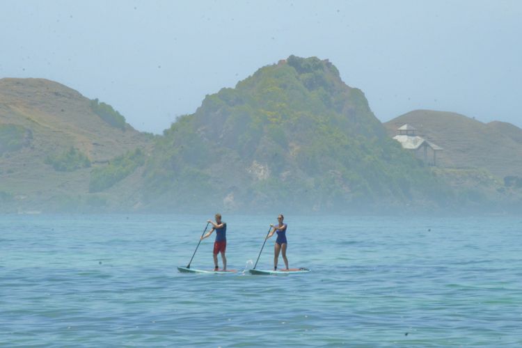 Dua wisatawan mancanegara bermain stand up paddleboard atau berselancar menggunakan dayung  di Pantai Mandalika, Kuta, Praya, Lombok Tengah, NTB, Selasa (10/10). Pantai Mandalika yang berada dalam Kawasan Ekonomi Khusus Mandalika dan termasuk dalam 10 destinasi wisata prioritas nasional ini memiliki daya tarik berupa pantai sepanjang 14,6 km yang membentang dari barat hingga ujung timur Pantai Tanjung Aan dengan keunikan pasir putihnya menyerupai biji merica. ANTARA FOTO/Ahmad Subaidi/kye/17 