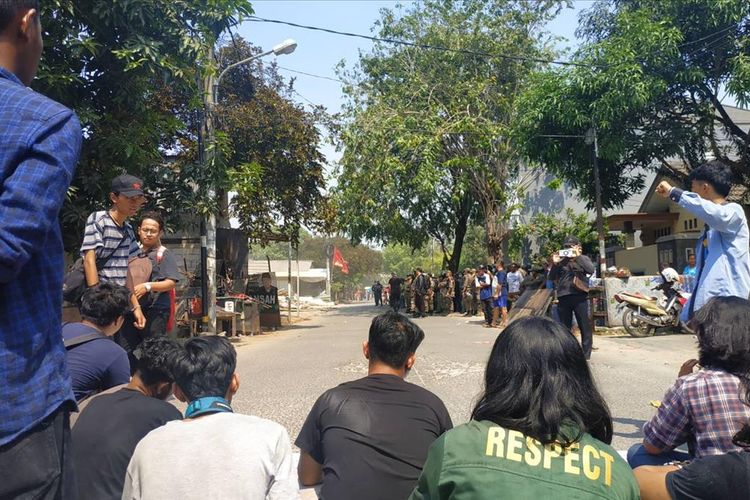Sejumlah pemuda bertahan di terik siang sebagai bentuk penolakan terhadap penggusuran rumah warga di Jalan Bougenville Raya RT 001 RW 011 Jakasampurna, Bekasi Barat, Kamis (25/7/2019).