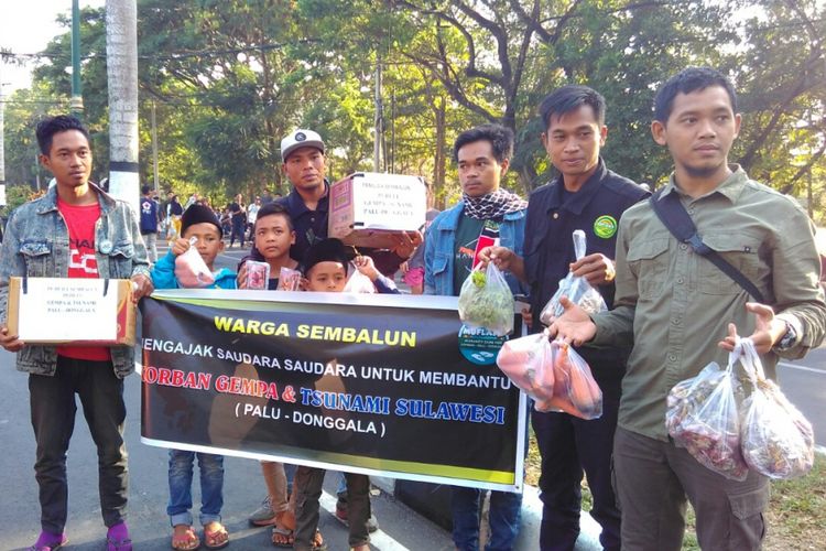 Warga Sembalun, korban gempa Lombok, menggalang dana dan membagikan stroberi gratis ke pengunjung CFD Mataram, Minggu (7/10/2018). 