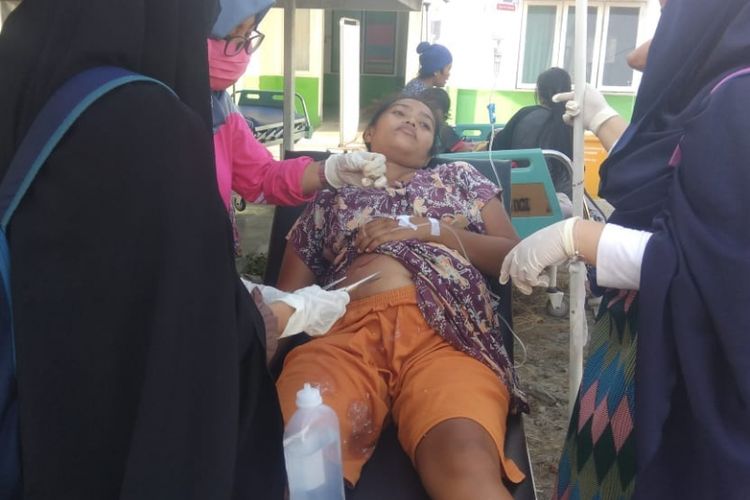 Petugas medis mengobati warga yang terluka akibat gempa di Donggala, Sulawesi Tengah, Jumat (28/9/2018). 