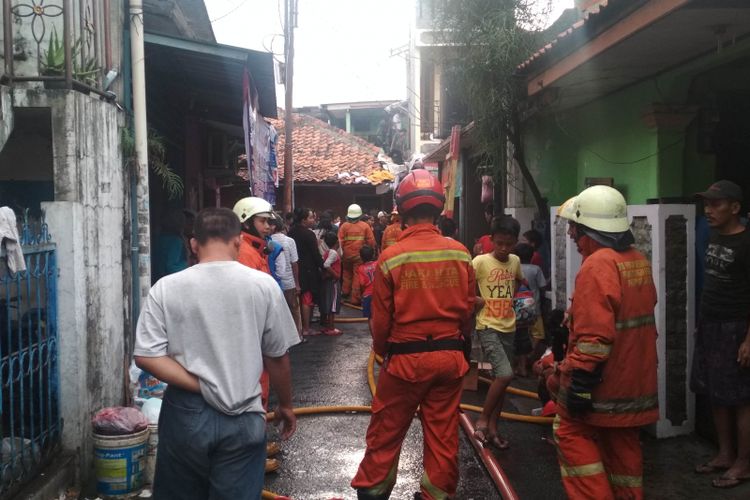 Petugas pemadam kebakaran memadamkan api yang menghangsukan lima rumah warga di Pondok Indah, Jakarta Selatan, Senin (28/1/2019)