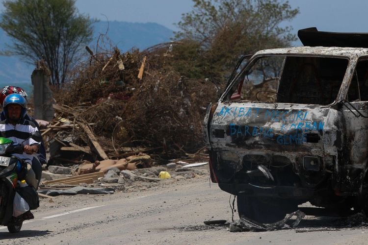 Mobil dibakar warga setelah kedapatan melakukan pencurian di Dupa Tondo, Kelurahan Layana, Kecamatan Mantikulore, Kota Palu, Sulawesi Tengah, Selasa (2/10/2018). Pasca gempa dan tsunami di Palu dan Donggala, warga diresahkan oleh maraknya aksi penjarahan dan pencurian.