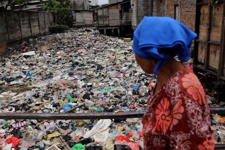 Warga melintas di Kali Gendong, Waduk Pluit, Penjaringan, Jakarta Utara, Selasa (14/3/2017). Kurangnya kesadaran masyarakat membuang sampah sembarangan mengakibatkan sampah plastik dari rumah tangga nyaris menyerupai daratan tersebut menumpuk di sepanjang Kali Gendong.