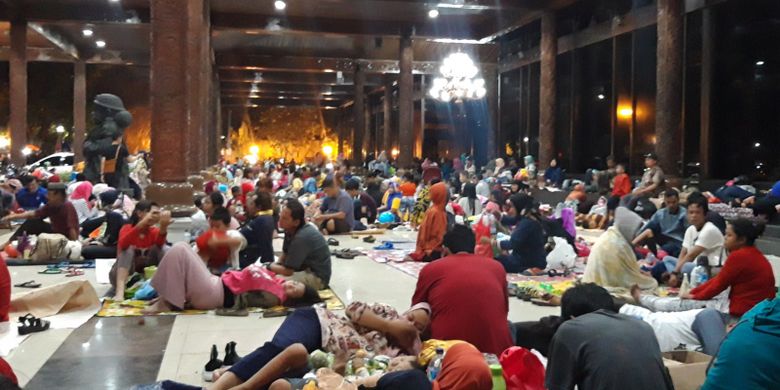Pengunjung menggelar tikar di depan gedung Sasono Utomo TMII, Jakarta Timur, Senin (31/12/2018)