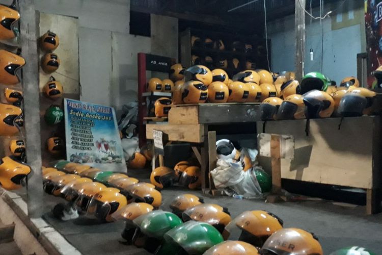 Helm mirip seragam pengemudi ojek online yang dijual di bangunan semi permanen di Jalan Galunggung, Setiabudi, Jakarta Selatan, Selasa (27/3/2018).