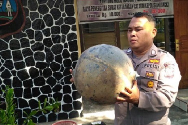 Seorang polisi di Polsek Tanjung Raya, Kabupaten Agam, Sumatera Barat, memegang benda yang jatuh dari udara, Selasa (18/7/2017). 
