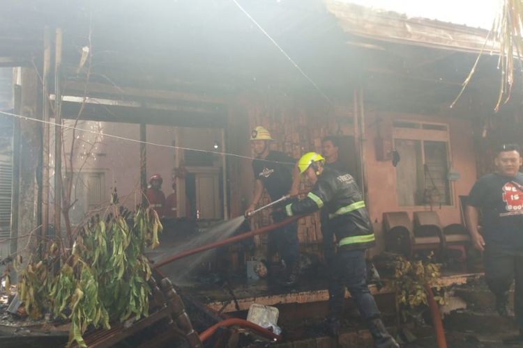 Petugas pemadam kebakaran Kota Solo sementara memadamkan api yang membakar rumah Heru Subiantoro, warga Bonorejo, RT 07 RW 16, Nusukan, Banjarsari, Solo dilalap api Rabu (23/5/ 2018).