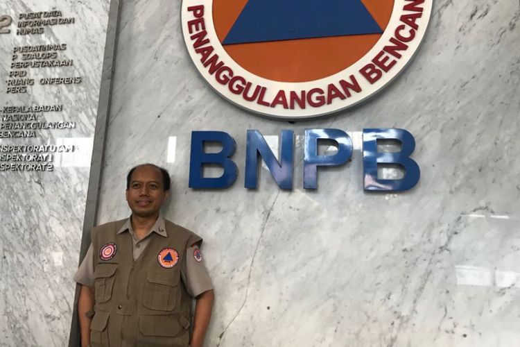Sutopo Purwo Nugroho berfoto di depan lambang Badan Nasional Penanggulangan Bencana (BNPB), Kamis (4/10/2018)