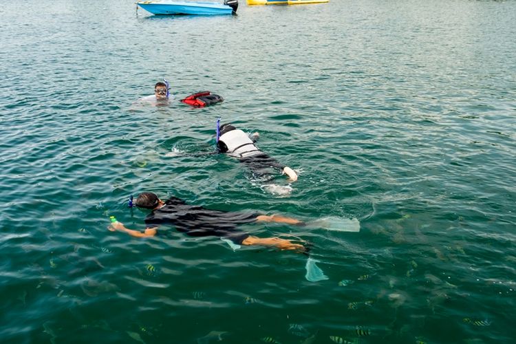 Wisatawan snorkeling di Pantai Basring.