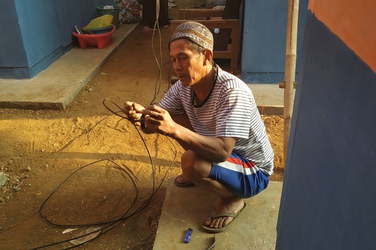 Seorang penyintas memassng instalasi listrik sendiri yang disambungkan ke jaringan listrik yang terdapat di hunian sementara (huntara) Nyalindung, Sukabuni, Jawa Barat, Selasa (3/9/2019).