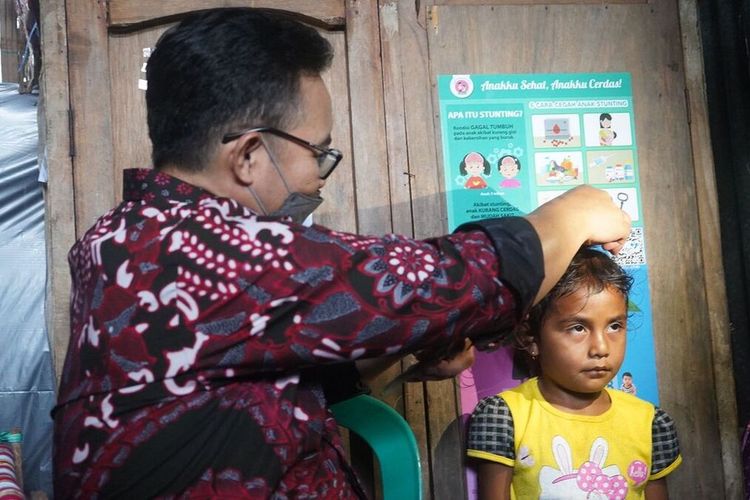 Kepala Badan Kependudukan dan Keluarga Berencana Nasional (BKKBN) Hasto Wardoyo mengukur tinggi badan seorang anak di Soe, Kabupaten Timor Tengah Selatan, Nusa Tenggara Timur, Selasa (22/3/2022). Sebanyak 48 dari 100 balita di sana mengalami stunting. 