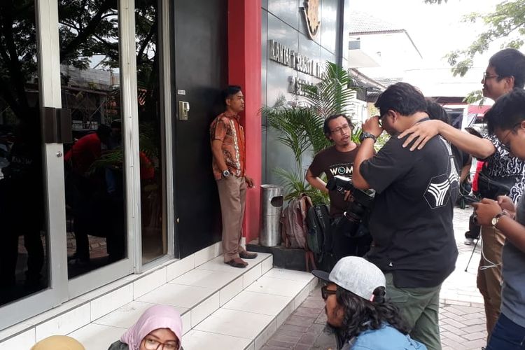 Puluhan wartawan bergerombol di depan salah satu pintu masuk gedung Ditreskrimsus Polda Jawa Timur, Jumat (15/3/2019) siang.