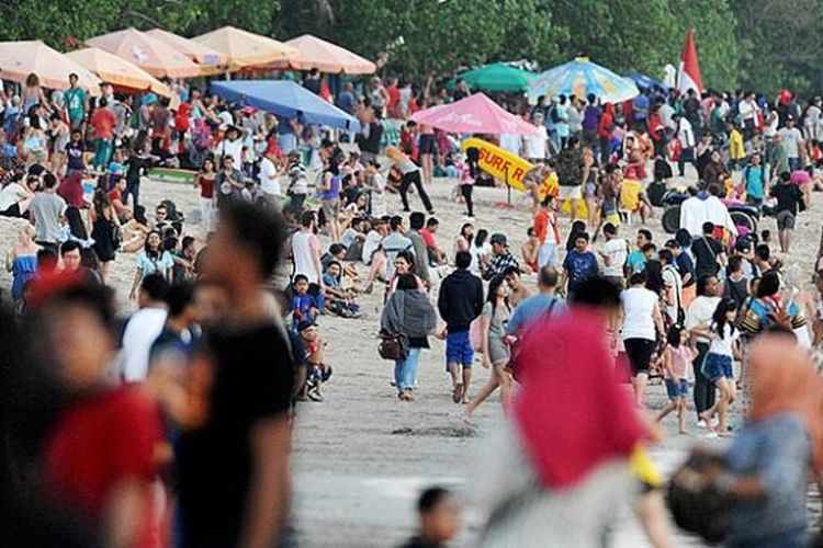 Ribuan wisatawan, baik asing maupun domestik, memadati kawasan Pantai Kuta, Kabupaten Badung, Bali, untuk menunggu matahari terbit, Rabu (17/8/2016). Pantai Kuta merupakan obyek wisata pantai paling terkenal di Bali yang selalu penuh wisatawan pada musim liburan.