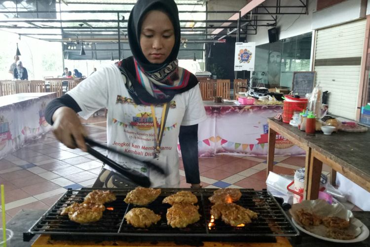 Desi (20) memanggang steak yang terbuat dari jengkol, pada Festival Jengkol Indonesia, Sabtu (18/11/2017).