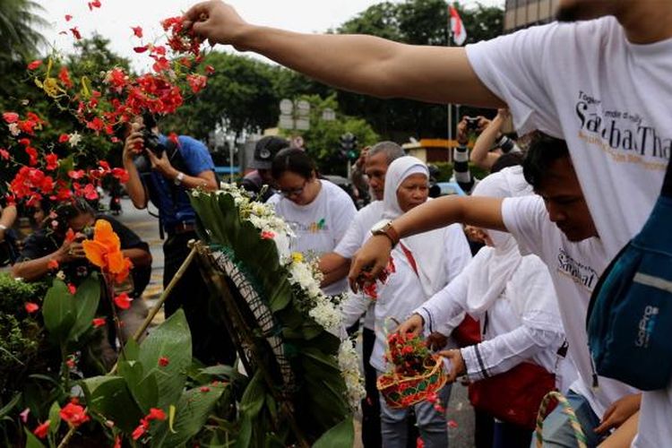 Massa yang tergabung dalam Sahabat Thamrin, Yayasan Penyintas, dan Aliansi Indonesia Damai (AIDA) melakukan tabur bunga di Sarinah, Thamrin, Jakarta, Sabtu (14/1/2017). Mereka mengenang kembali aksi terorisme yang terjadi siang hari setahun sebelumnya.