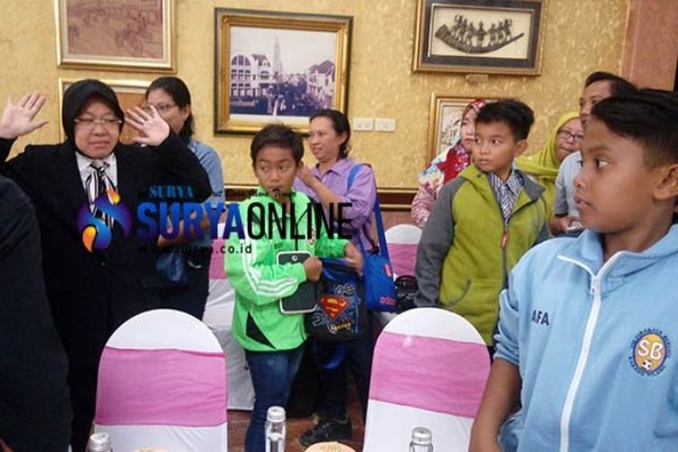 Tri Rismaharini menyapa anak-anak siswa sekolah sepak bola sebelum kedatangan perwakilan Liverpool di lobi lantai 2 Balai Kota Surabaya, Senin (19/3/2018). 