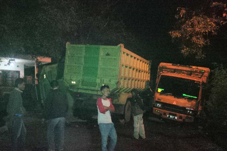 Sejumlah warga berjaga-jaga di lokasi kejadian tiga truk tronton kecelakaan di Kampung Ciangsana, Kecamatan Cikembar, Sukabumi, Jawa Barat, Minggu (9/9/2018). 