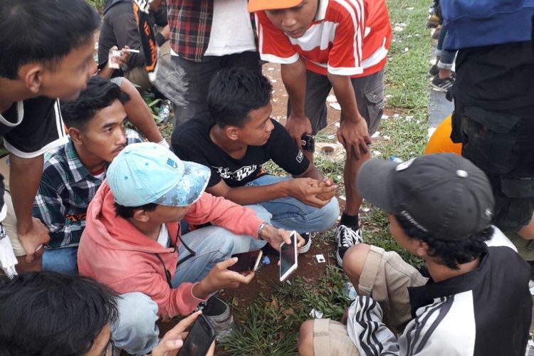 Sekelompok suportee Persija menonton pertandingan lewat layanan streaming di Jalan Gerbang Pemuda, Minggu (9/12/2018).