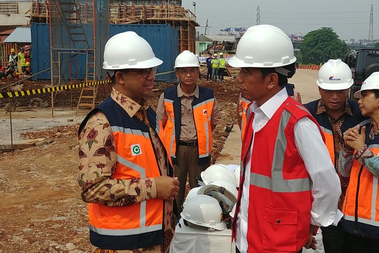 Presiden Joko Widodo berbincang dengan Gubernur DKI Jakarta Anies Baswedan di lokasi proyek tol Becakayu, di Muara Cipinang, Jakarta Timur, Jumat (3/11/2017).