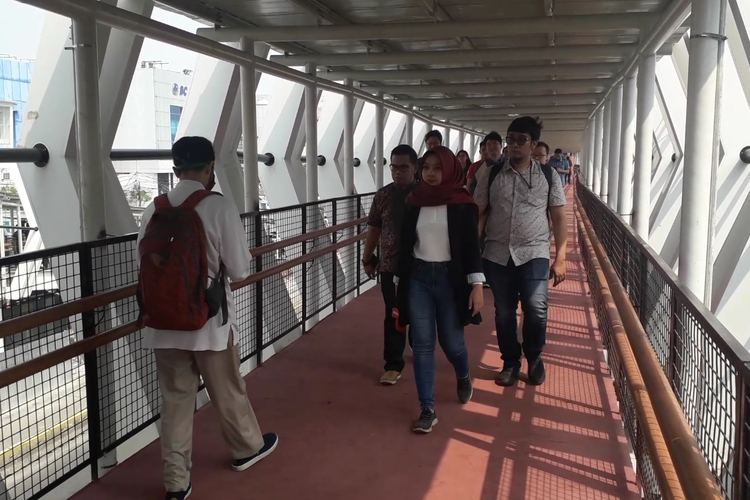 Warga melintas di skybridge penghubung Stasiun LRT Velodrome dan Halte Transjakarta Pemuda yang baru dibuka, Jumat (21/6/2019).