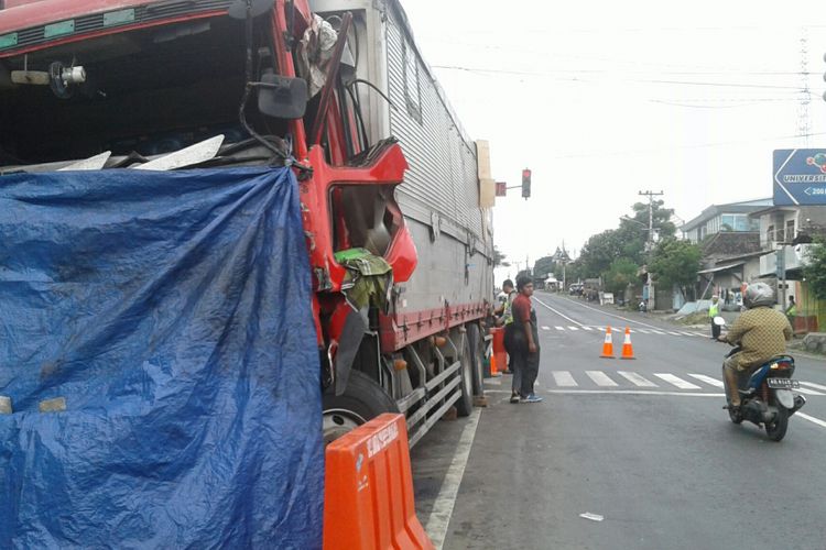 Pengendara sepeda motor melintas di samping truk tronton yang terlibat kecelakaan karambol di perempatan lampu merah Jalan Sumpah Pemuda di Kelurahan Mojosongo, Kecamatan Jebres, Solo, Jawa Tengah, Rabu (7/3/2018).