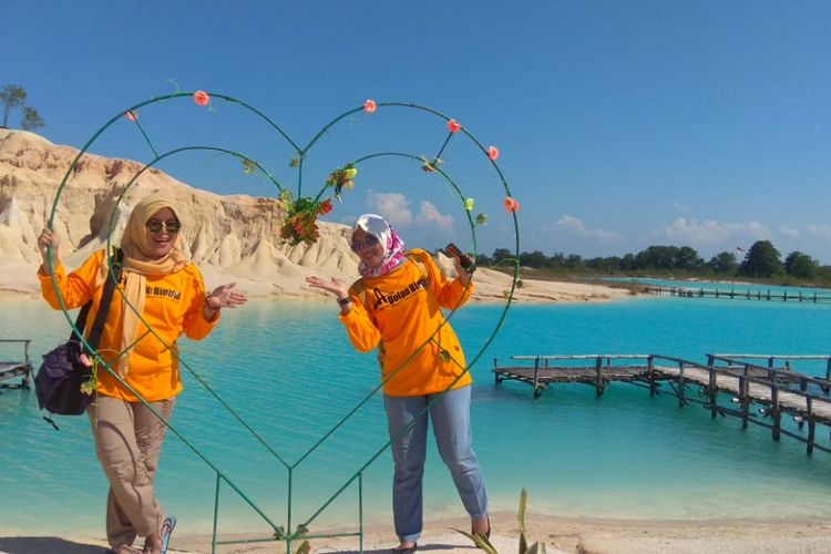 Wisatawan berpose di ornamen buatan yang disediakan pengelola di Gurun Telaga Biru Bintan, Kepulauan Riau, belum lama ini.